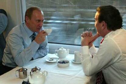 Vladímir Putin (izquierda) charla con Gerhard Schröder a bordo de un tren de alta velocidad, en diciembre de 2004.