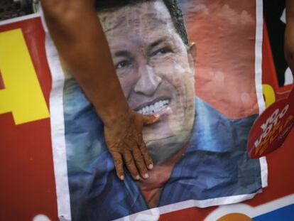 A Ch&aacute;vez supporter touches a campaign poster of the president during a PSUV rally Sunday