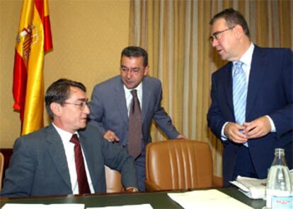 El forense José Luis Prieto conversa con el presidente y vicepresidente de la comisión, durante su comparecencia en el Congreso.