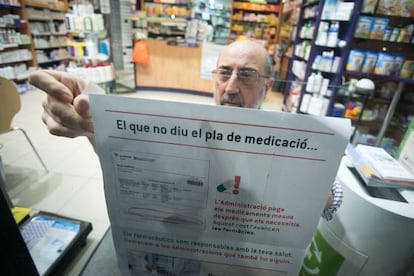 Un farmacéutico cuelga los carteles de protesta, ayer en Barcelona