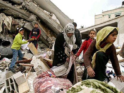 Varios niños miran entre los escombros de uno de los cuatro edificios derruidos en busca de sus pertencencias.