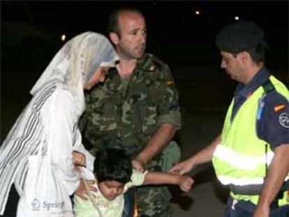 Dos militares asisten en Torrejón de Ardoz a una mujer y a un niño evacuados de Irak.