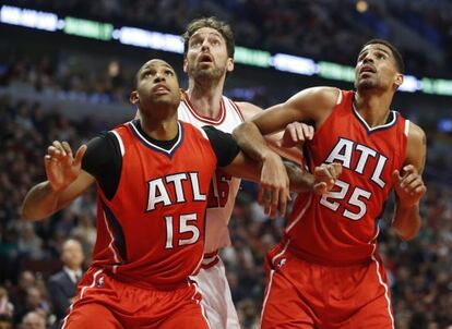 Dos jugadores de los Hawks bloquean a Pau Gasol