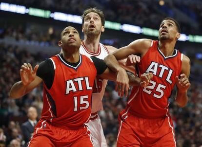 Dos jugadores de los Hawks bloquean a Pau Gasol 