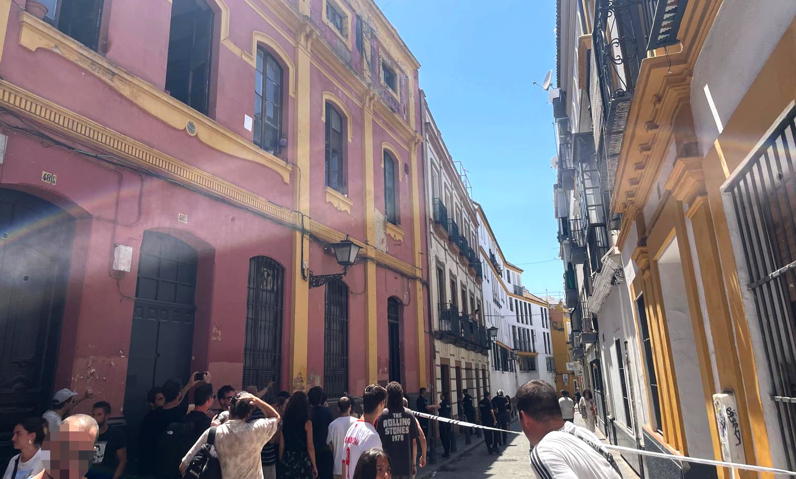 Agentes de la Policía Nacional precintan el acceso a la vivienda allanada por una empresa 'desokupa' en Sevilla.