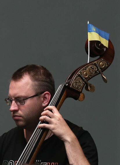 Uno de los músicos de la Orquesta de Kiev, con una bandera ucrania en su chelo.