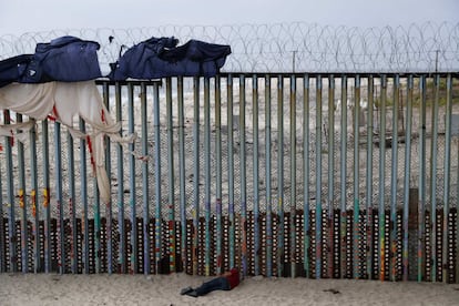 Un hombre duerme junto a la frontera con Estados Unidos, en Tijuana (Mexico).