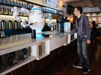 Adam, a robot, prepares coffee for a customer at the Botbar coffee shop in New York on May 31, 2023.