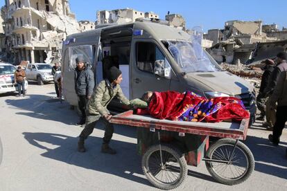 Un hombre traslada a una mujer herida en Alepo.