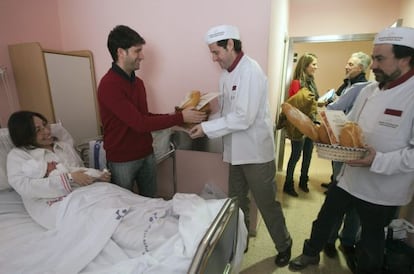 Representantes del gremio de panaderos entregan una barra de pan a Leire, la primera niña que ha nacido en Álava y en Euskadi y que recibirá una barra cada día todo el año.