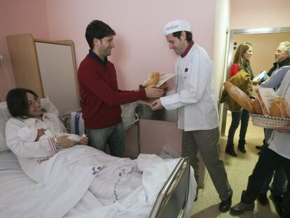 Representantes del gremio de panaderos entregan una barra de pan a Leire, la primera niña que ha nacido en Álava y en Euskadi y que recibirá una barra cada día todo el año.
