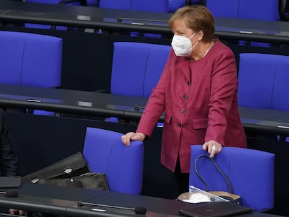 German Chancellor Angela Merkel talking with Finance Minister Olaf Scholz inside the Bundestag.