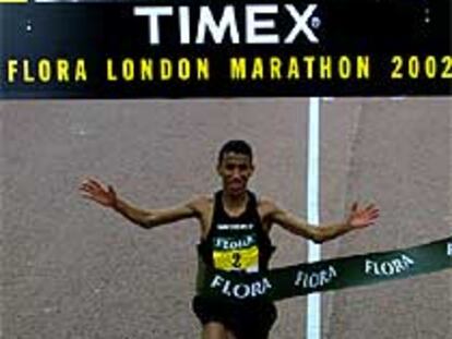 Januchi gana y bate su récord. Gebreselassie muestra su trofeo.