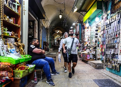 Un israelí, armado con un fusil de asalto, pasa por delante de un comerciante árabe en la ciudad vieja de Jerusalén, el 29 de noviembre.