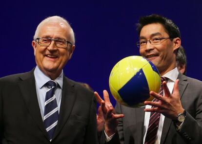 Rainer Br&uuml;derle (izquierda) recibe un bal&oacute;n de Philip R&ouml;sler en el congreso de los liberales, en Berl&iacute;n.