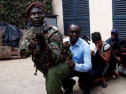 Varias personas son evacuadas de la zona atacada con la ayuda de un soldado keniano.