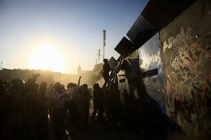 Mujeres intentan subir la vallas metálicas que las separan de los edificios gubernamentales en el Zócalos.