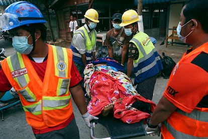 Miembros de un equipo voluntario de rescate transportan a una mujer herida en las protestas, este domingo en la ciudad de Mandalay (Myanmar).