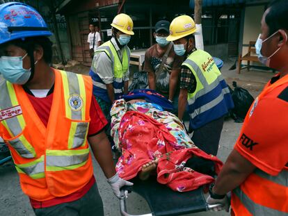 Miembros de un equipo voluntario de rescate transportan a una mujer herida en las protestas, este domingo en la ciudad de Mandalay (Myanmar).