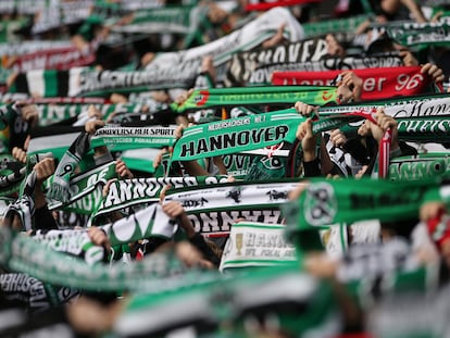 Aficionados del Hannover 96 levantando sus bufandas durante un partido de la Bundesliga.