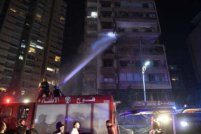 Los bomberos tratan de extinguir las llamas del edificio bombardeado en Beirut, la madrugada del lunes. 