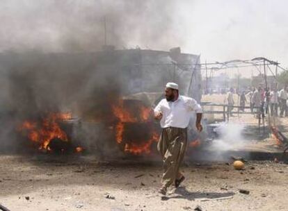 Un hombre corre frente a un vehículo en llamas tras un atentado suicida en Kirkuk (norte de Irak).
