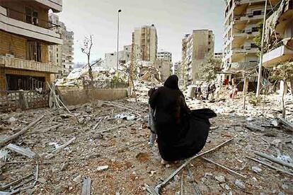 Una mujer libanesa lleva las pertenencias que ha sacado de su apartamento destruido en el sur de Beirut.