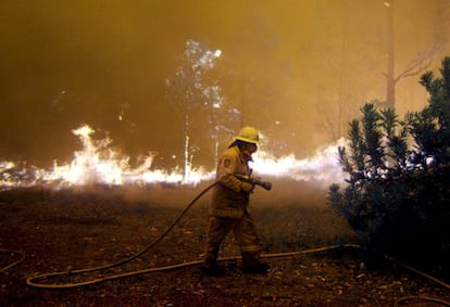 Un bombero intenta sofocar un incendio cerca de Sidney en 2002.