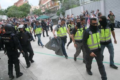 Agentes de la policía nacional retiran urnas en Tarragona el pasado domingo.