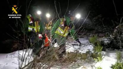 Dos agentes de rescate, ya con el cuerpo del montañero fallecido.