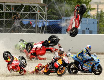 Loris Capirosi y Sete Gibernau (arriba) vuelan, mientras Marco Melandri (abajo izquierda) permanece en el suelo, tras Dani Pedrosa (centro, nmero 26) y Hopkins (derecha), durante la espectacular cada masiva durante la primera vuelta de la carrera de MotoGP de Catalu?a, el 18 de junio de 2006.