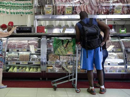 Clientes compram carne em açougue de São Paulo.