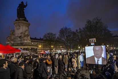 Integrantes del movimiento nacido en redes sociales "La Nuit Debout" observan una intervención del presidente Francois Hollande en París.