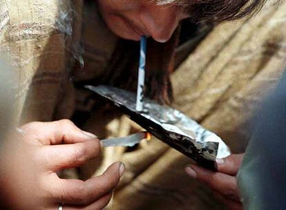 Un hombre inhala los vapores de heroína desprendidos de un <i>chino</i> (especie de cigarrillo de papel de aluminio).