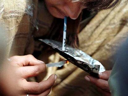 Un hombre inhala los vapores de heroína desprendidos de un <i>chino</i> (especie de cigarrillo de papel de aluminio).