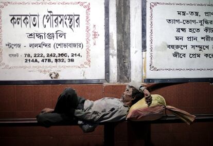 Un trabajador descansa en una estación de autobús en Calcuta (India).
