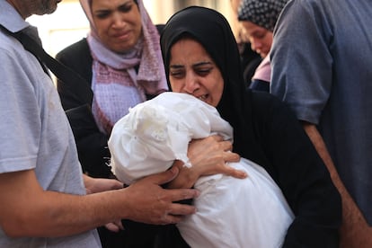 Familiares llevan el cuerpo del bebé Ahmed Barhom, de 8 meses, durante su funeral en Rafah junto al resto de los miembros de la misma familia muertos por un bombardeo israelí, este lunes.