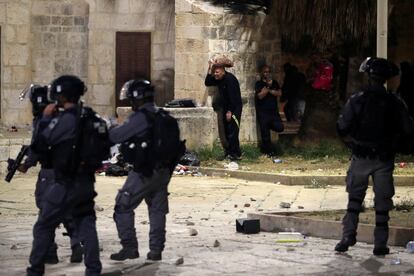 El barrio musulmán de la Ciudad Vieja quedó acordonado y las fuerzas israelíes cerraron el paso a través de la emblemática Puerta de Damasco. En la imagen, varios palestinos se ponen a cubierto durante los enfrentamientos con la policía israelí en el recinto que alberga la mezquita de Al-Aqsa.