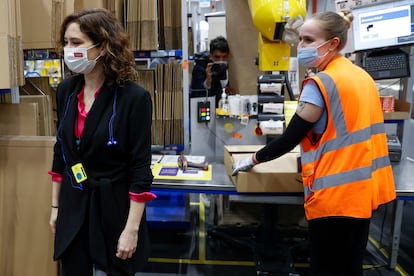 La presidenta de la Comunidad de Madrid, Isabel Díaz Ayuso (a la izquierda), visita el centro logístico de Amazon en Alcalá de Henares (Madrid) este viernes.