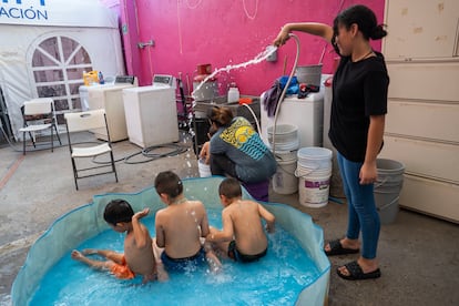 Niños se refrescan en una pequeña alberca en el albergue Cobina Posada del Migrante, en la ciudad fronteriza de Mexicali al norte de México. En julio 2024.