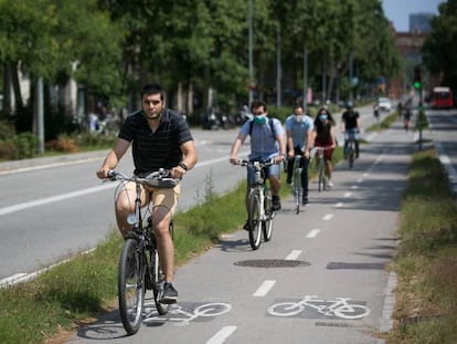 Varias personas se mueven en bicicleta por un carril bici de Barcelona. 