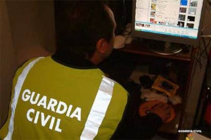 Un investigador de la Guardia Civil registra el ordenador de uno de los detenidos en Sevilla.