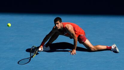 Carlos Alcaraz devuelve la pelota desde el suelo durante el partido contra Berrettini.