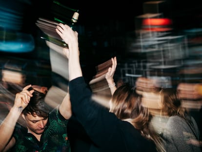 An energetic scene with people on the dancefloor dancing and drinking at a colourful, open air nightclub