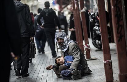 Un hombre sirio pide limosna con un niño en la avenida Istiklal, en Estambul. Naciones Unidas el 20 de enero 2014 canceló la invitación a Irán para asistir a una conferencia de paz de Siria esta semana por su negativa a respaldar las convocatorias de un gobierno de transición en Siria, dijo un portavoz.