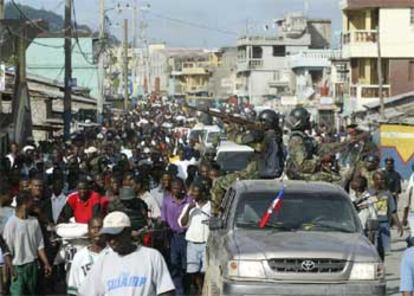 Los ciudadanos de Cabo Haitiano celebran la toma de la ciudad por los revolucionarios escoltados por un convoy.