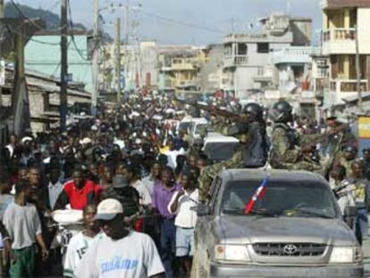 Los ciudadanos de Cabo Haitiano celebran la toma de la ciudad por los revolucionarios escoltados por un convoy.