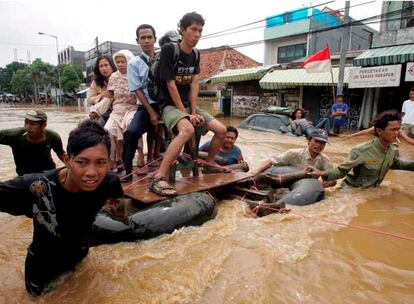 Ciudadanos indonesios tratan de mantenerse sobre una balsa mientras son remolcados por los miembros de los equipos de rescate indonesios a través de una calle inundada en Yakarta. Las precipitaciones han causado desde el jueves el desbordamiento de varios ríos y provocado el despliegue de un amplio dispositivo para rescatar a los damnificados.