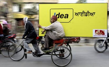 Un hombre transporta un cartel de la empresa de m&oacute;viles Idea, en Amritsar (archivo).