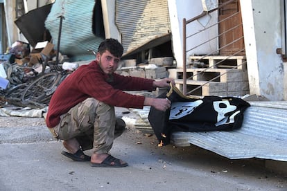 Un soldado de las tropas sirias apostado en Palmira quema una bandera de ISIS encontrada entre las viviendas hoy abandonadas.